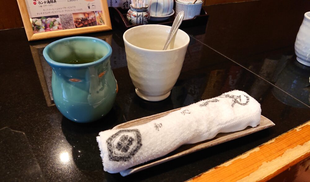 「和処 一暁(いちぎょう)」のお茶、コーヒーカップ、おしぼり。